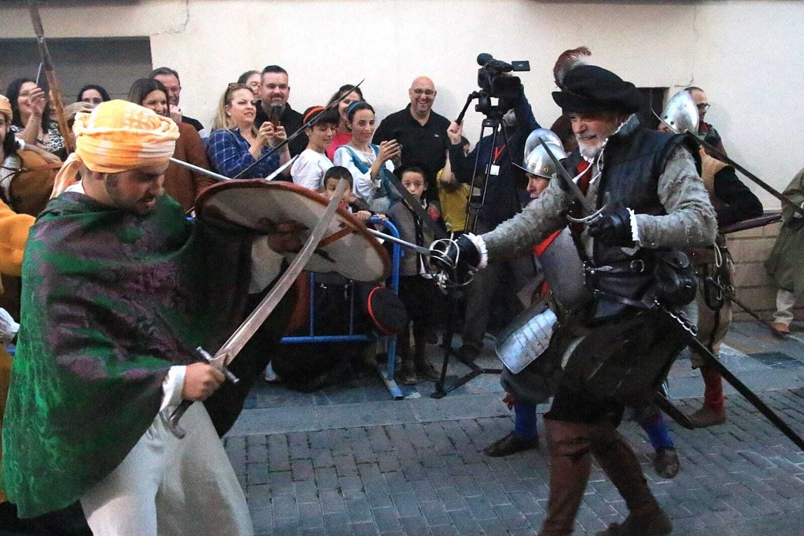 Moriscos y cristianos, ataviados con las vestimentas de la época, pelean por la ciudad.