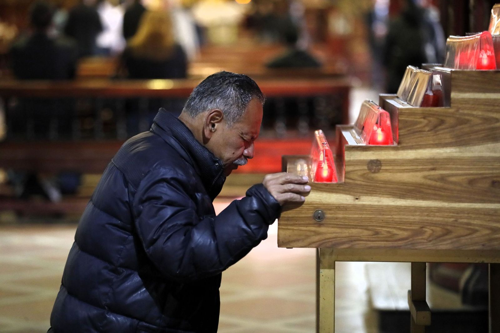 Un hombre reza en una iglesia.