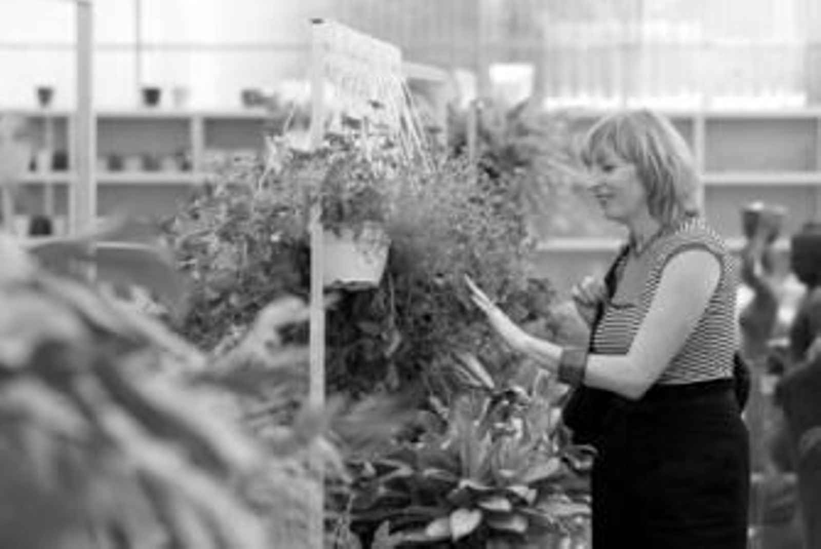 Una mujer mira unas macetas durante la visita al vivero.