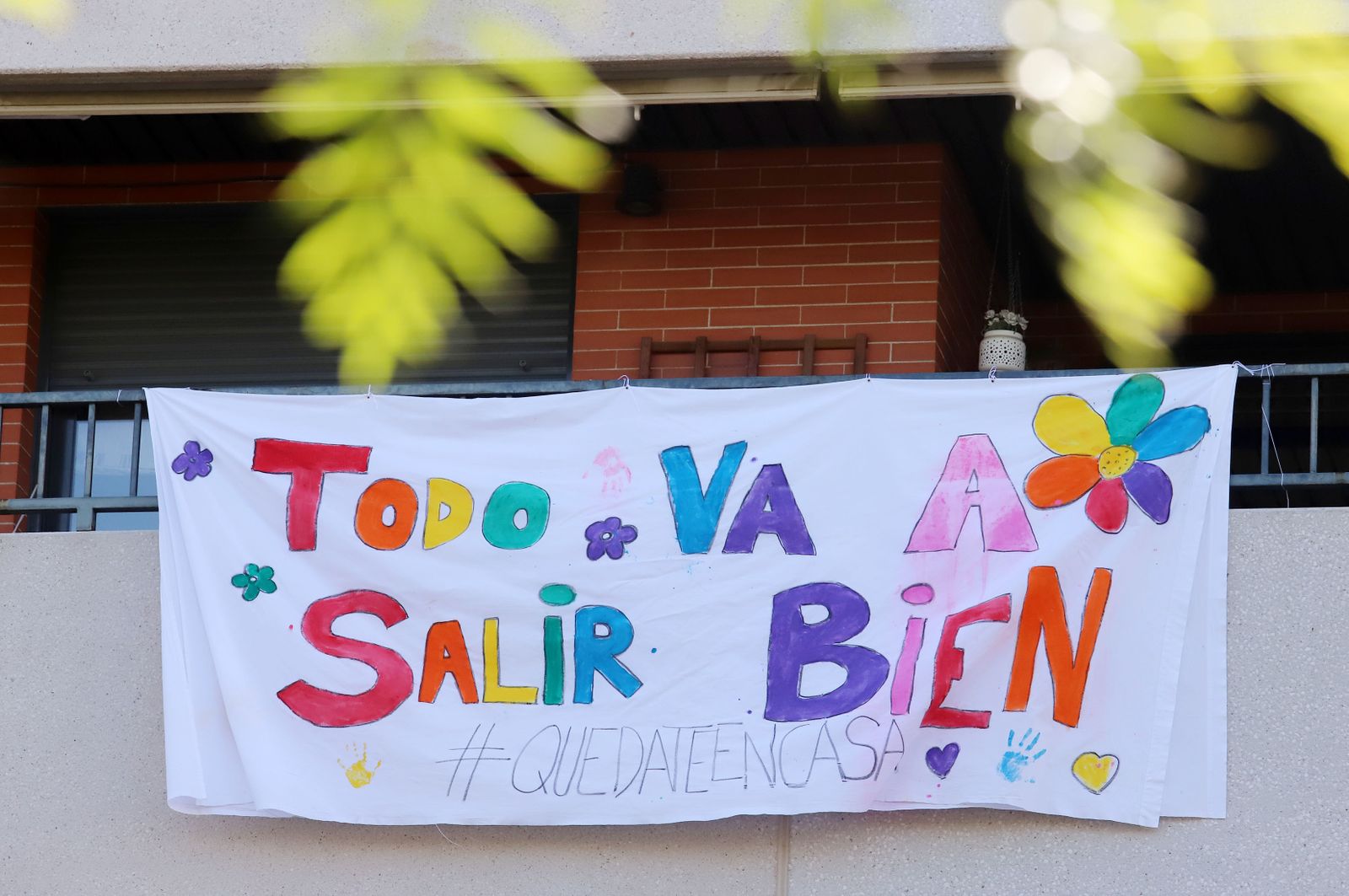 Una sábana sirve de soporte en un balcón para un mensaje positivo: "Todo va a salir bien".