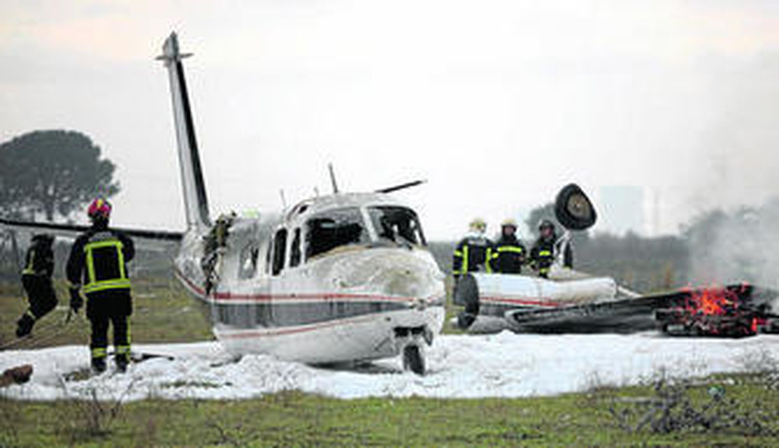 Los Bomberos voluntarios del parque de La Rinconada trabajan junto al avión siniestrado, en el simulacro organizado ayer junto al aeropuerto.