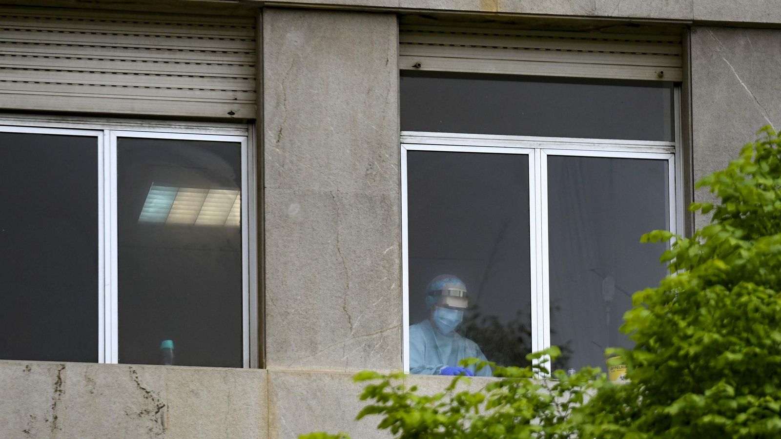 Un sanitario, tras una ventana en el viejo hospital Clínico en los primeros días del Covid