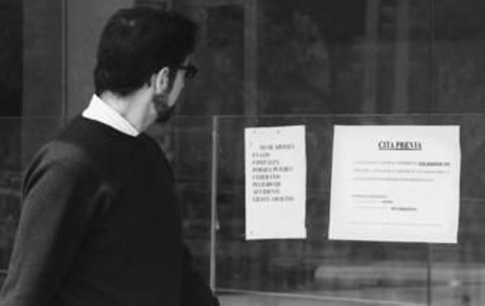 Un ciudadano lee el cartel que avisa de la puesta en marcha del sistema de cita previa, ayer en la comisaría de la Alameda.