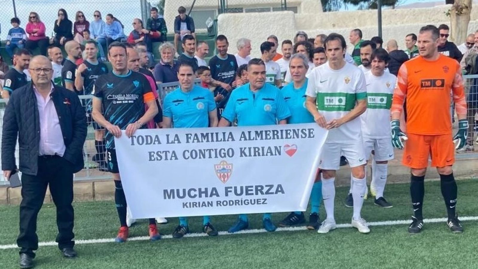 Los capitanes de ambos equipos posan con una pancarta en solidaridad con Kirian Rodríguez.