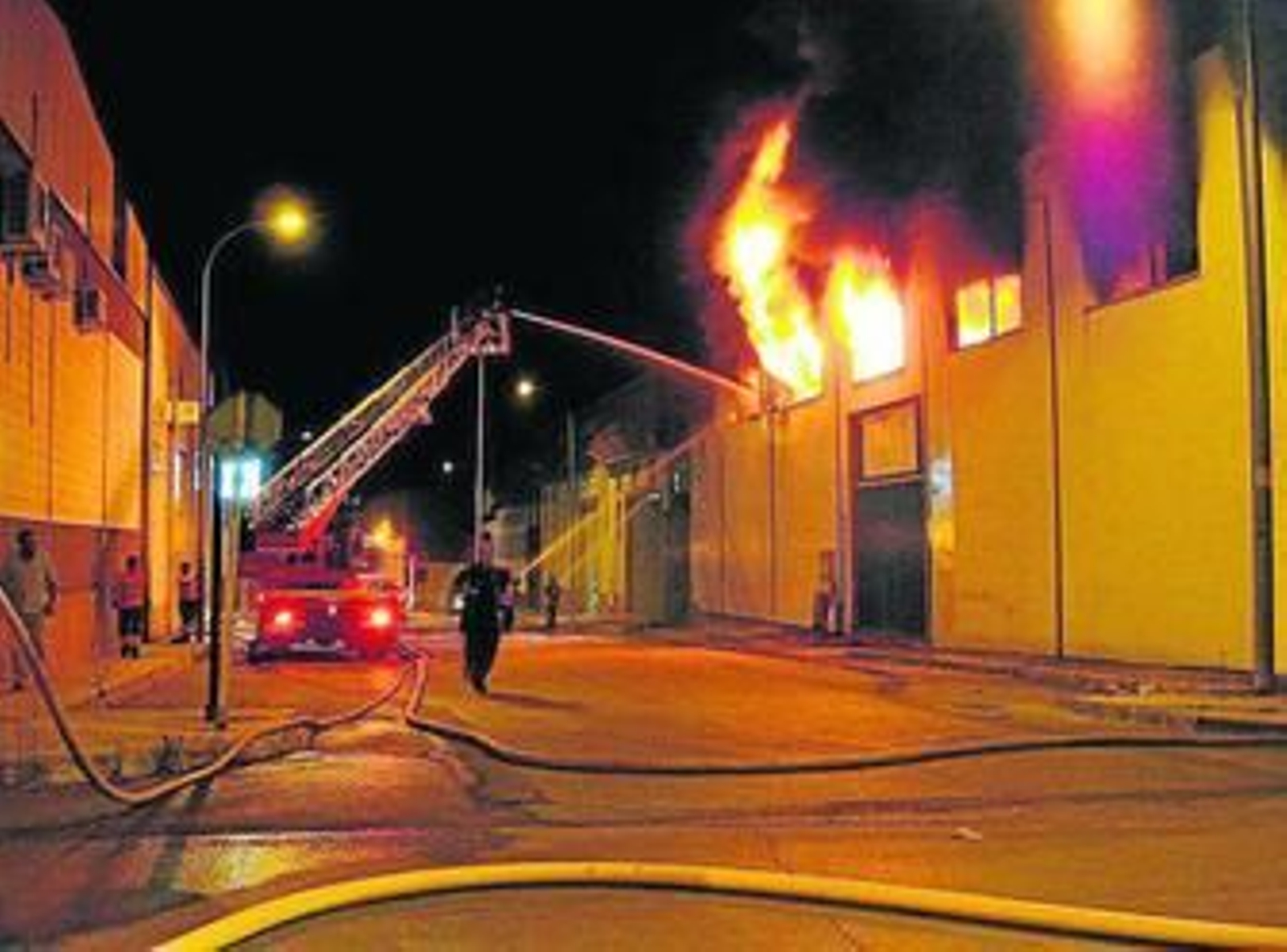 Los bomberos actúan en la nave siniestrada en el polígono de La Viñuela de Lucena.
