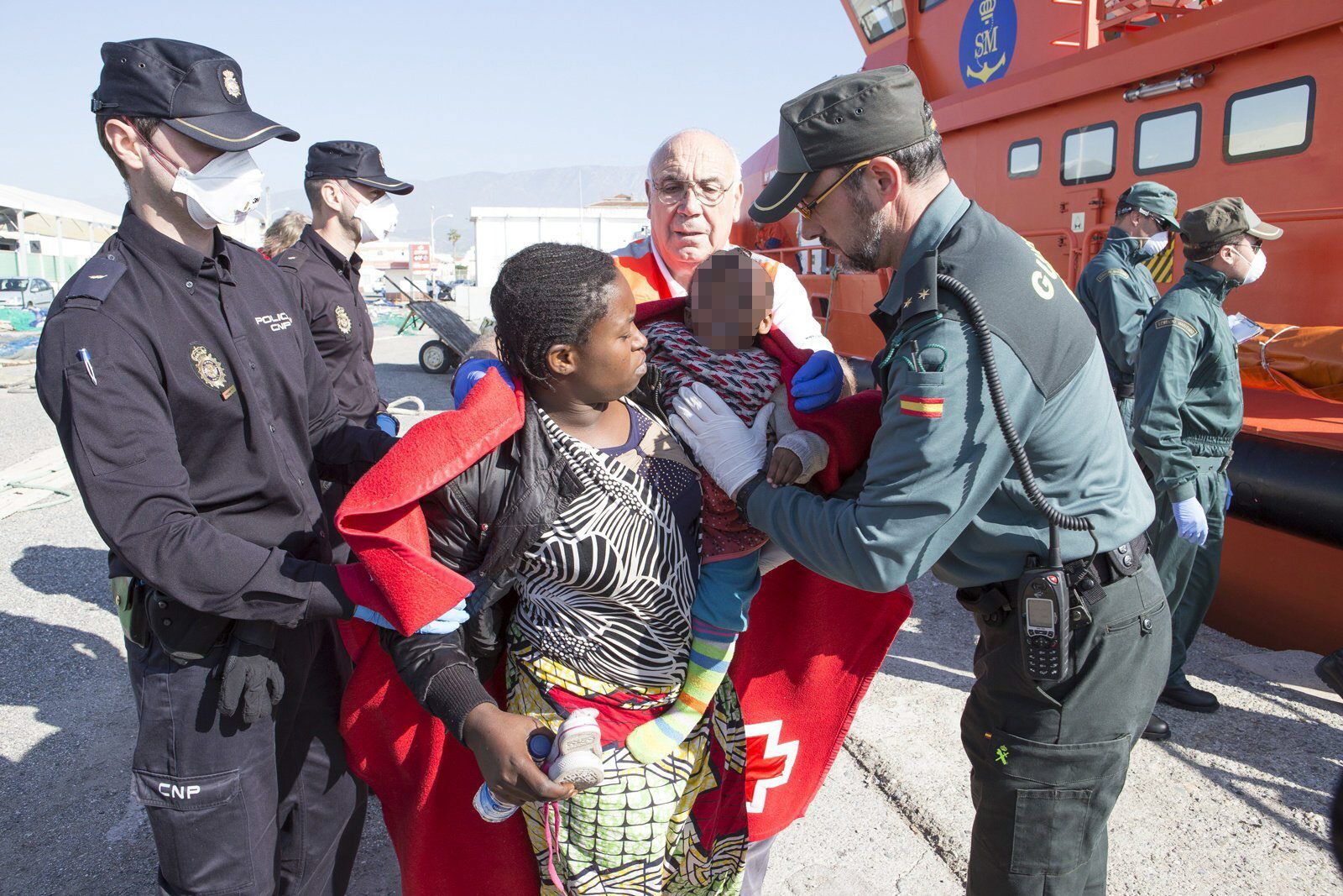 Agentes de la Policía Nacional y la Guardia Civil en una recepción de inmigrantes en Motril.