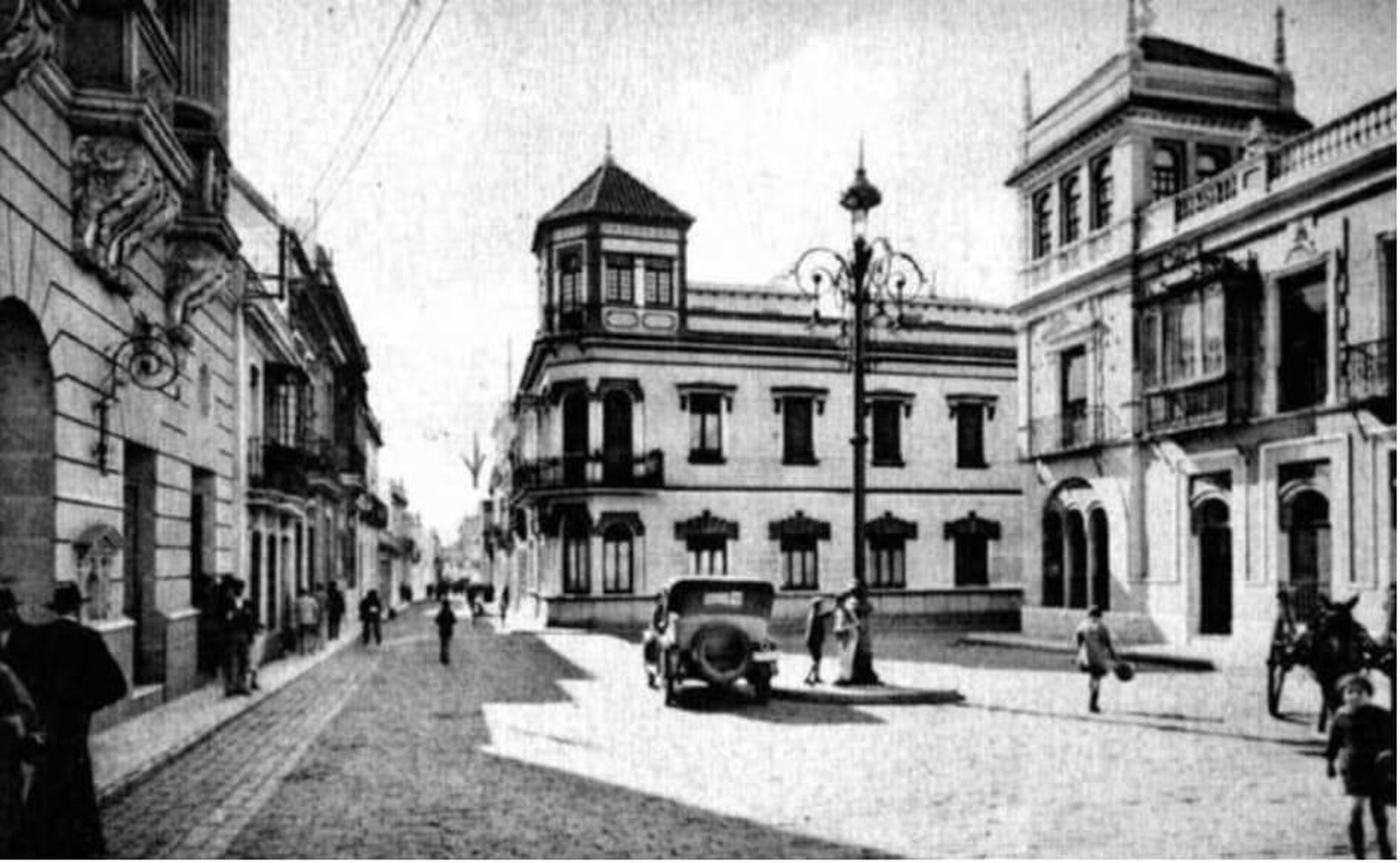 Calle Vázquez López, con un vehículo a motor y la fachada del Gran Teatro a la izquierda.