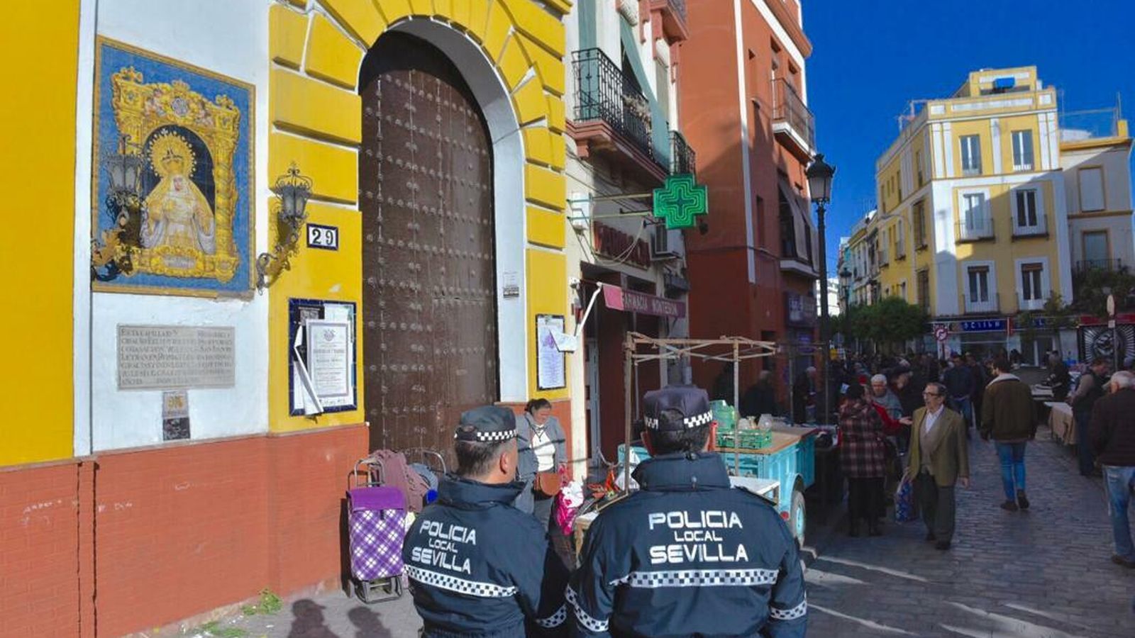 Dos agentes vigilan el mercadillo junto a la capilla de Montesión.