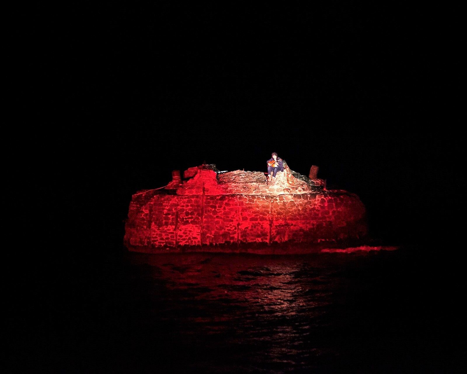 Guillermo Fernández durante su actuación con el mar separándolo del público.