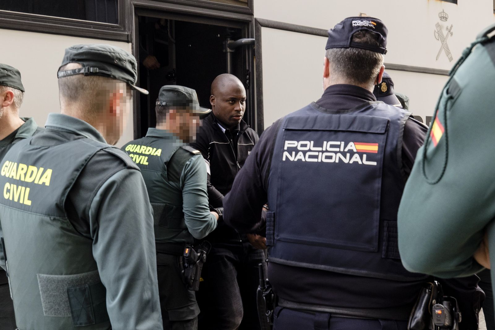 Uno de los acusados sale del furgón antes de entrar a juicio.