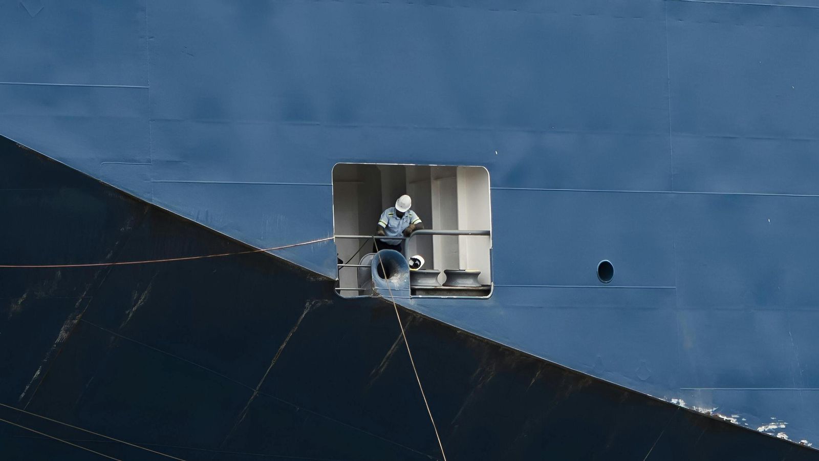 Trabajador en un carguero realizando tareas de mantenimiento.