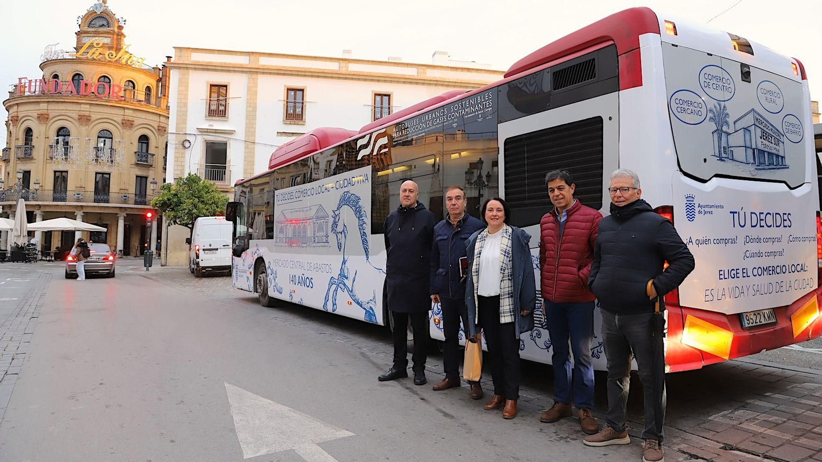 La delegada y los representantes de Adecosur, Asunico y Horeca, junto al autobús con la campaña de apoyo al comercio