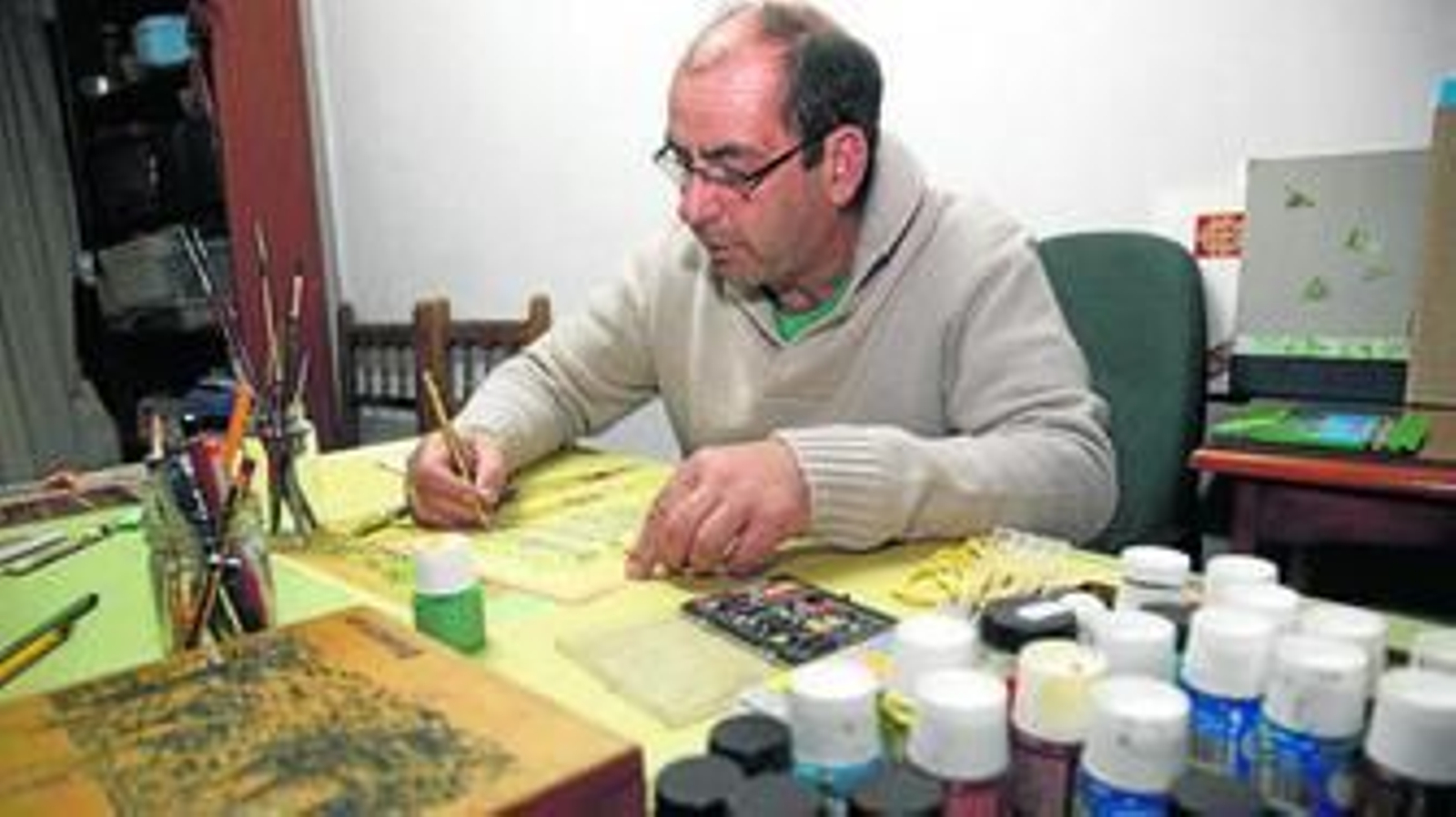 Rafael Méndez dando los últimos retoques a uno de sus trabajos y con algunos de los pergaminos ya terminados.