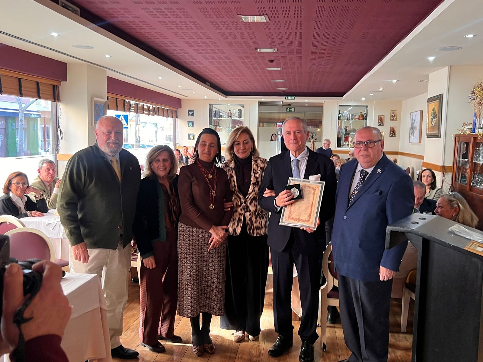Luis Capitán, con la placa y diploma recibido, junto a familiares y representantes del Ateneo de Triana.