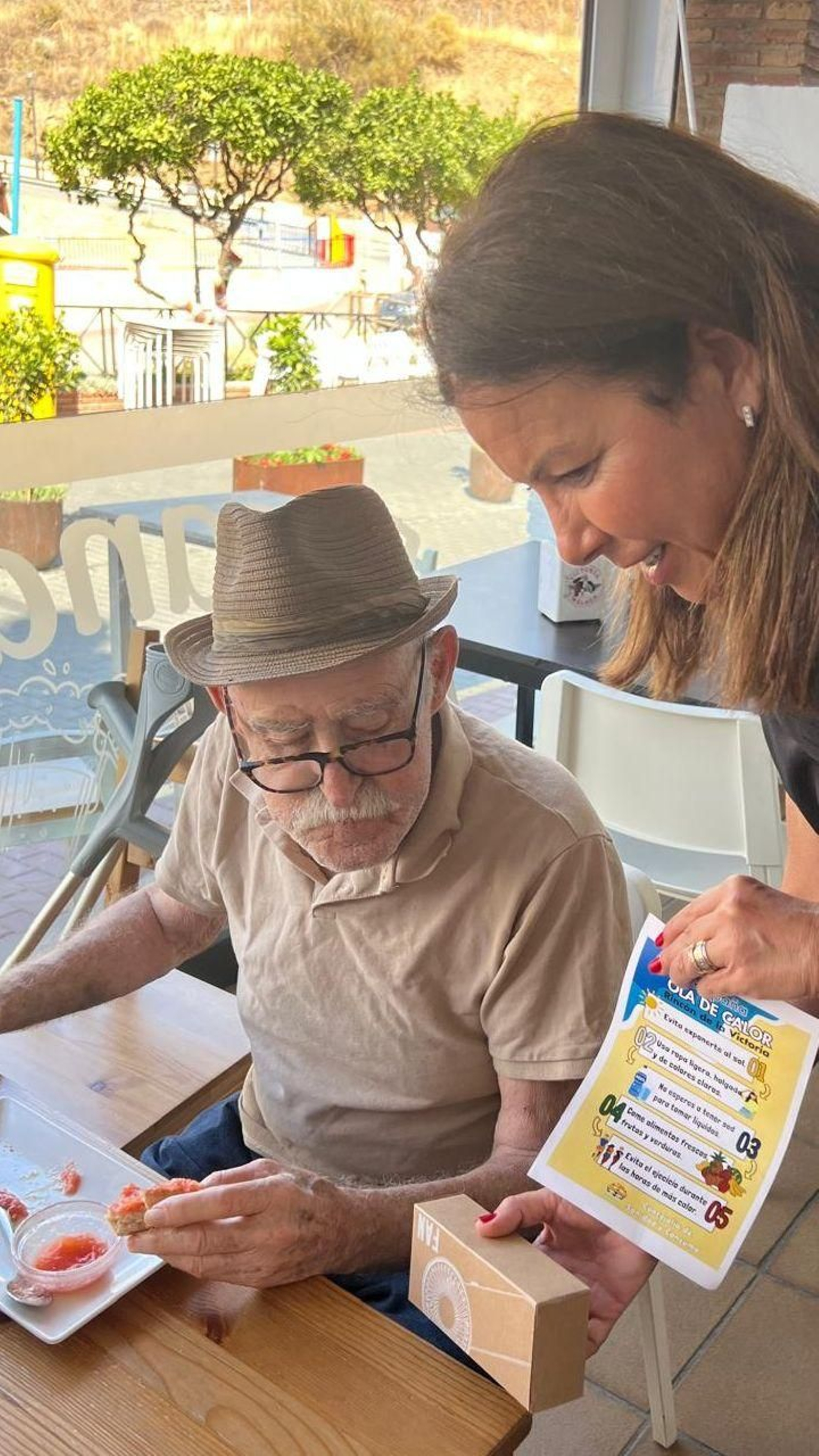 La concejala de Sanidad y Consumo entregando un flyer informativo y un ventilador a un ciudadano