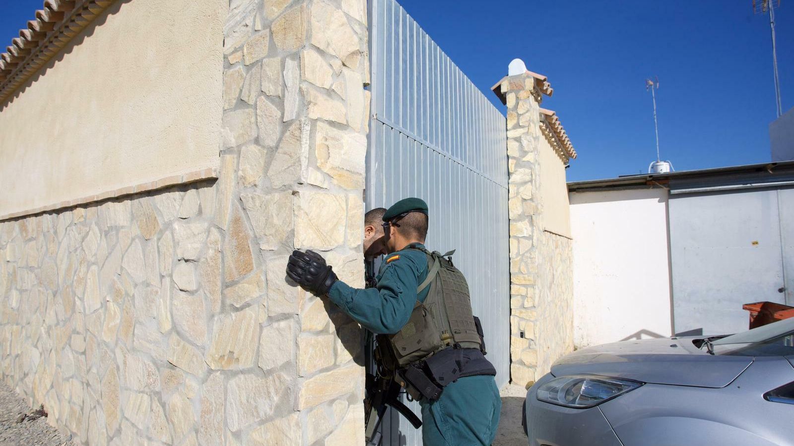 Un guardia civil, ante la puerta de un domicilio registrado en Trebujena.