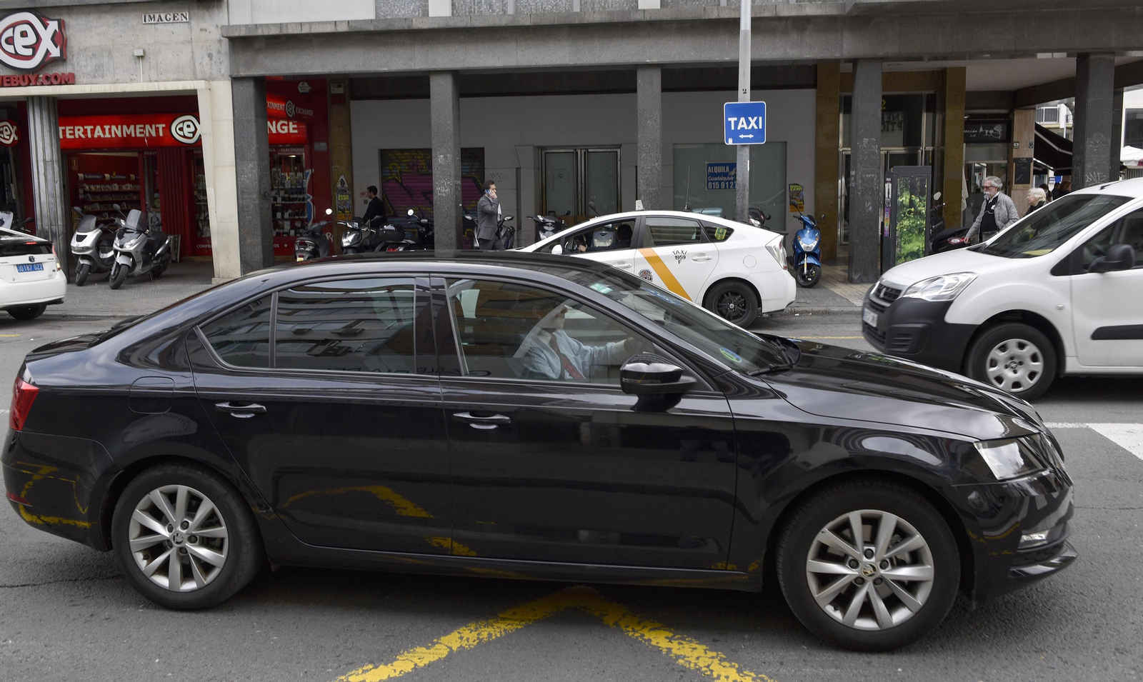 Una VTC (alquiler con conductor) pasa junto a una parada de taxi en el centro de Sevilla.