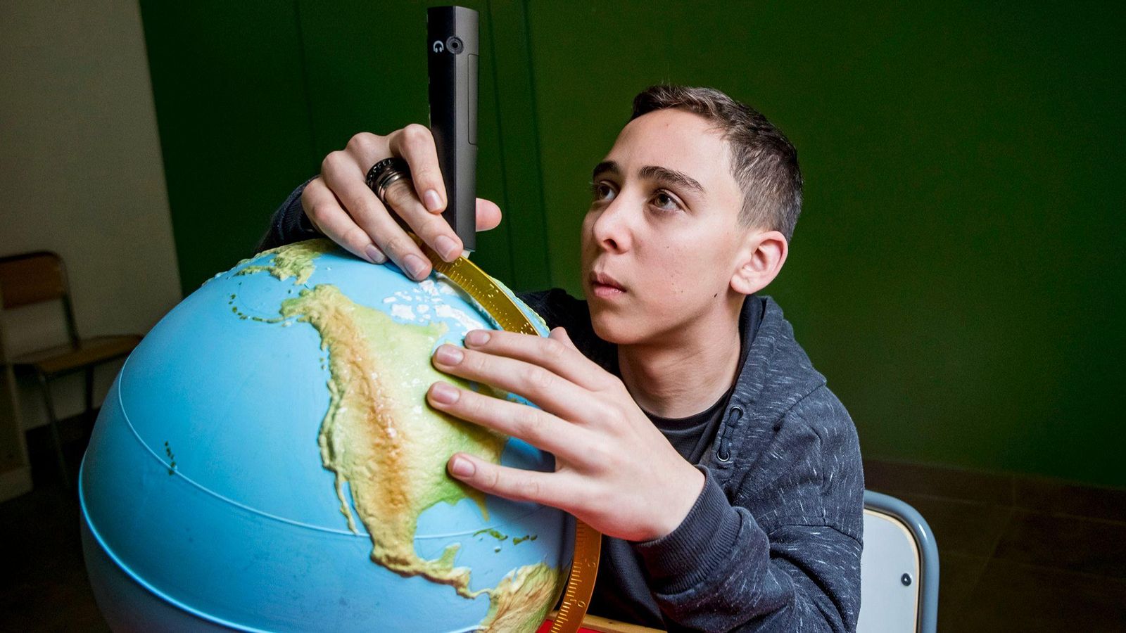 Alumno con bola del mundo adaptada.