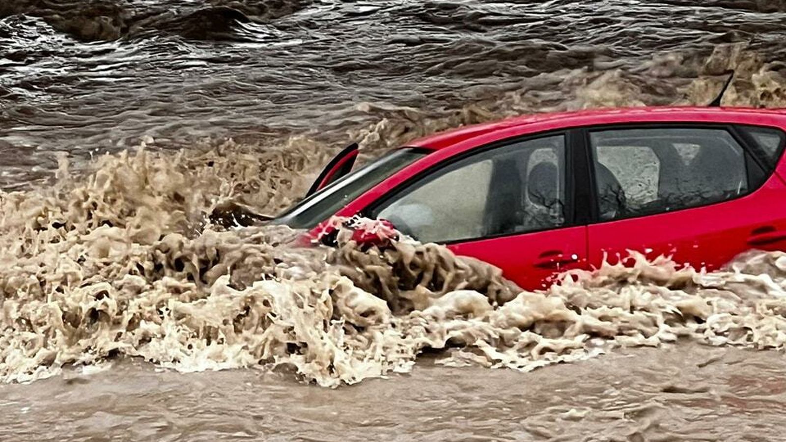 Vehículo encallado en las rocas tras ser arrastrado por la crecida del río