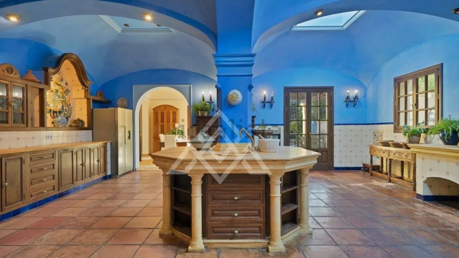 Cocina de gran formato, concebida como espacio central de trabajo y reunión dentro del complejo residencial.