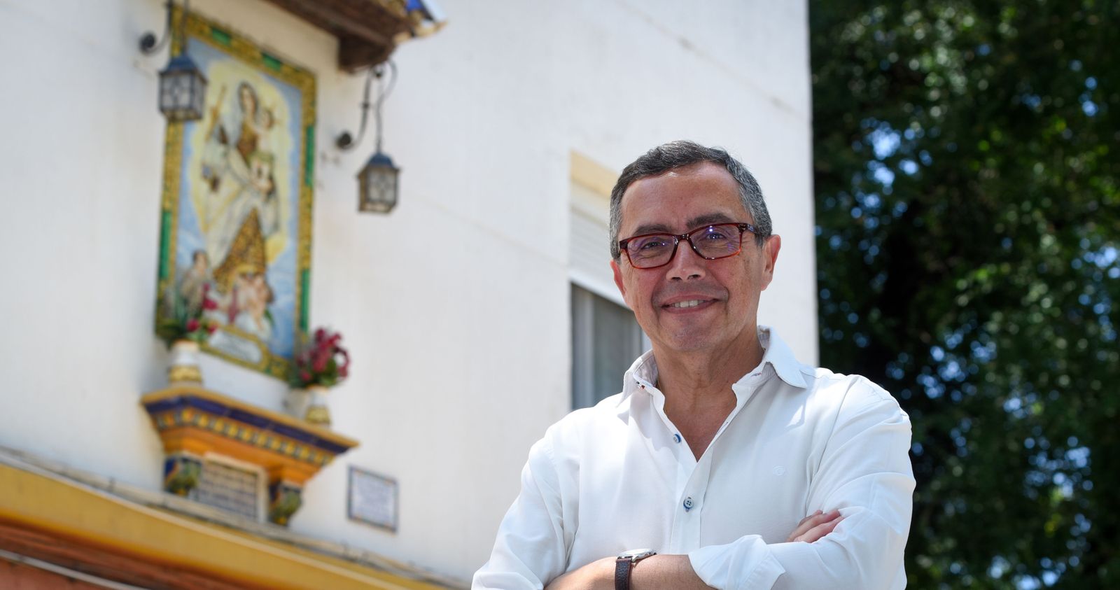 Práxedes Sánchez, vecino del barrio, junto al retablo de cerámica que donó Carmen Sevilla.