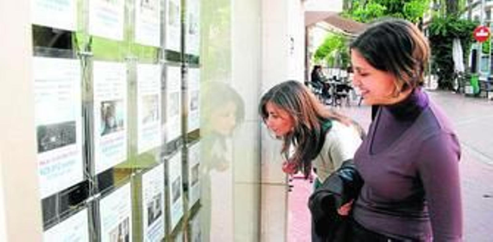 Dos mujeres se interesan por la oferta de una inmobiliaria de la capital onubense.