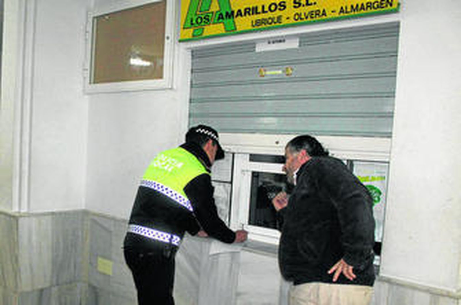 Uno de los empleados, ayer, informando a la Policía de lo ocurrido.