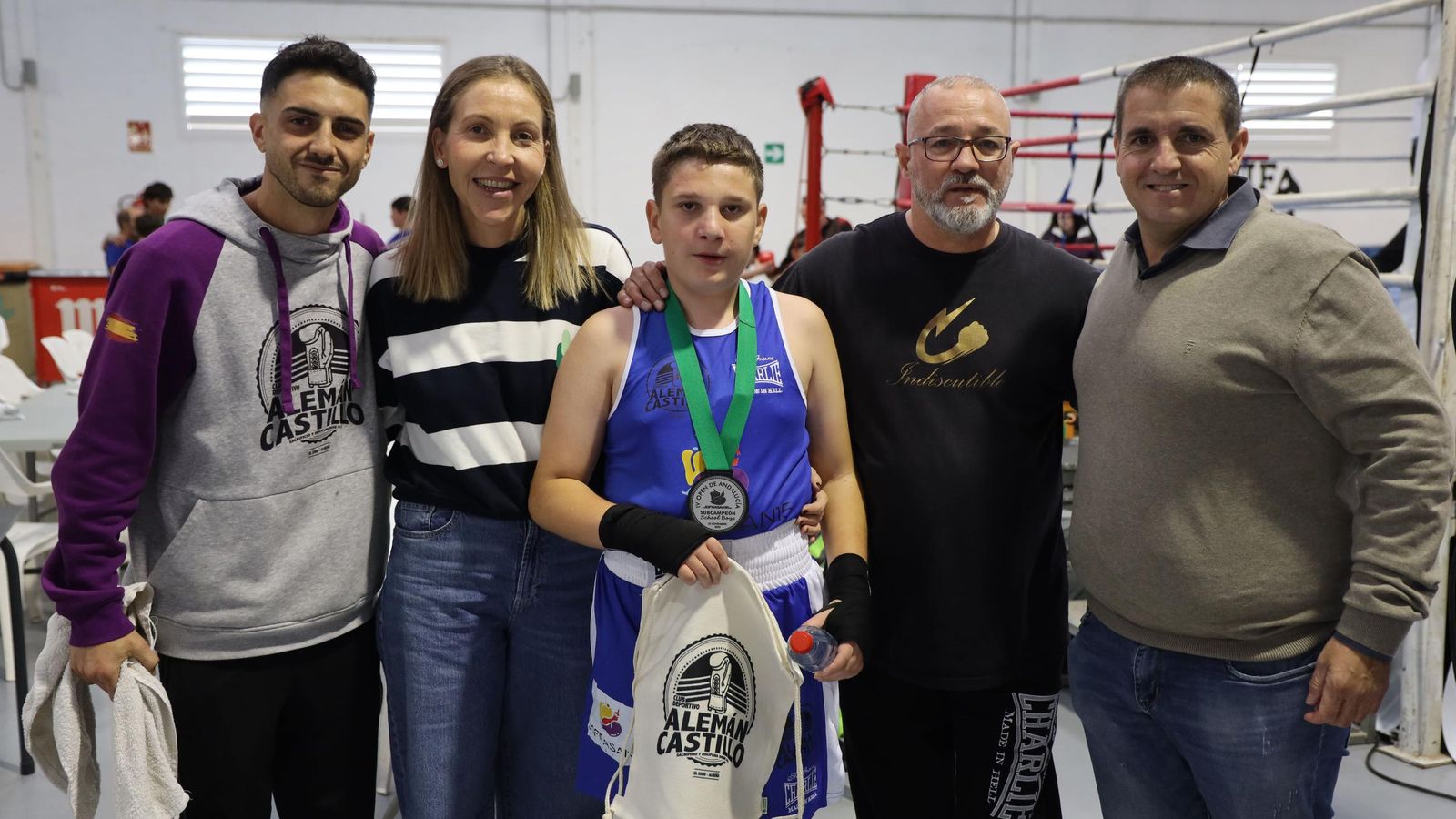 La concejala de Deportes y miembros del club organizador posan con uno de los boxeadores participantes.