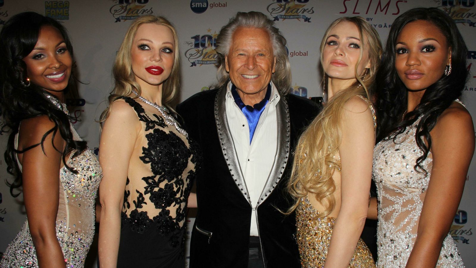 El magnate de la moda Peter Nygard, rodeado de modelos en un acto.
