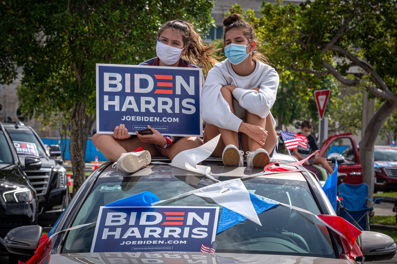 Dos jóvenes  sostienen una pancarta de apoyo a la fórmula "Biden Harris".