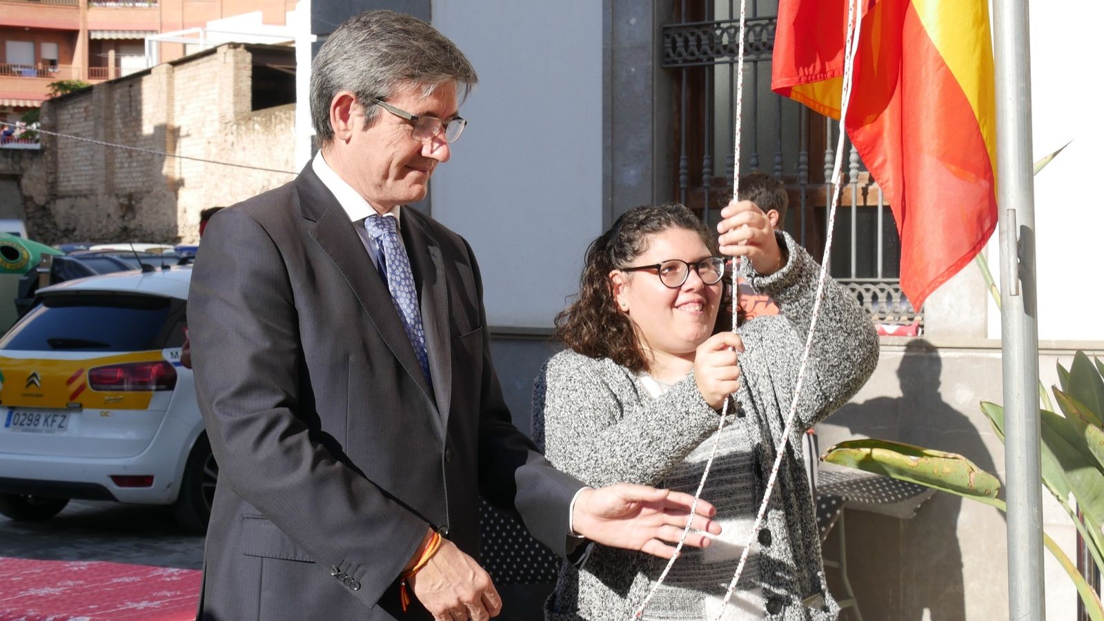 Izado de la bandera por una usuario del Centro Ocupacional.
