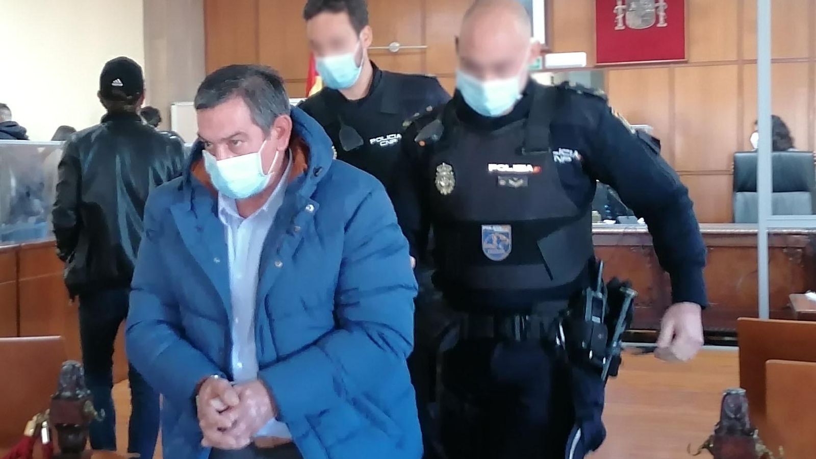 Lucas P. R. abandona la sala de vistas de la Audiencia de Jaén escoltado por dos policías.