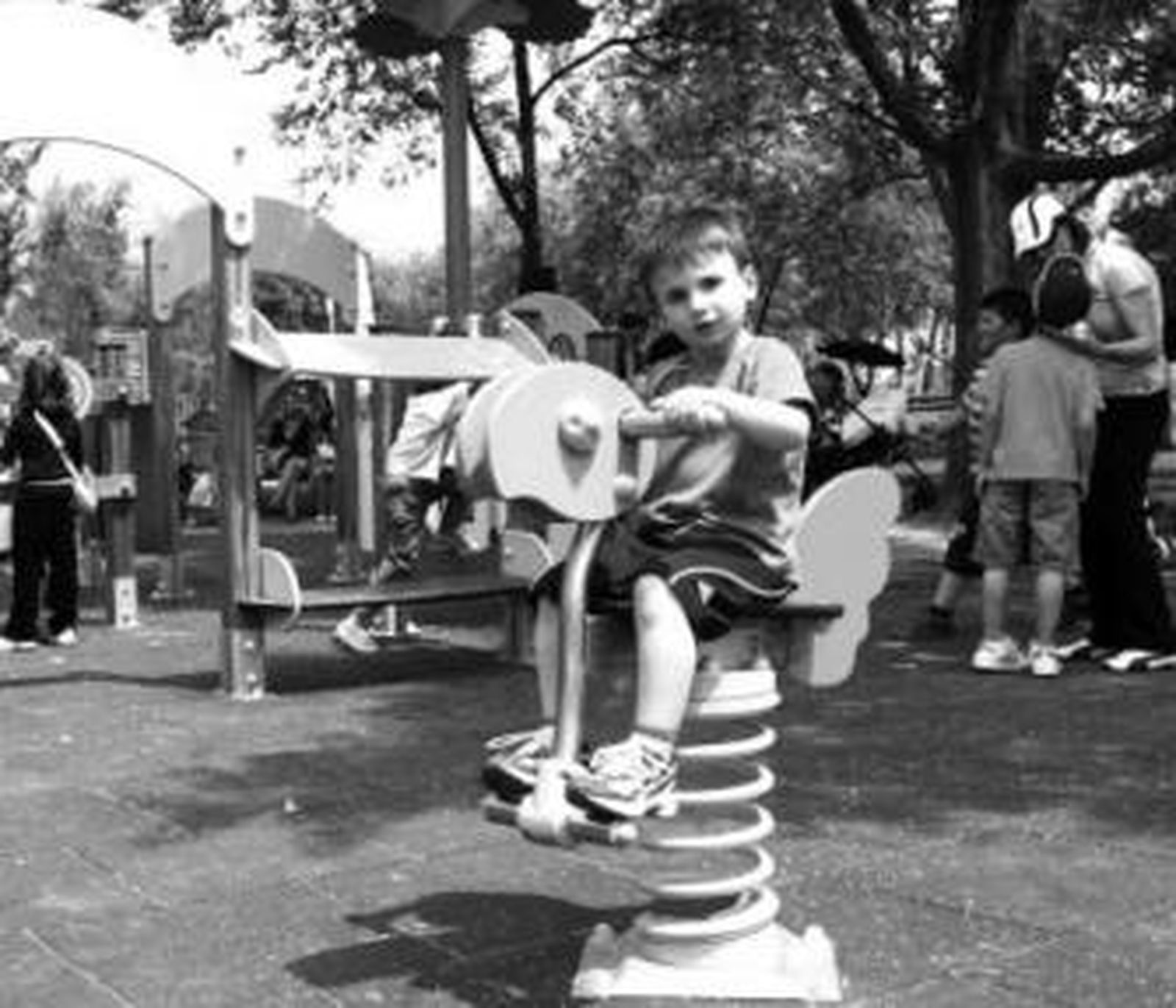 Un niño juega en un balancín en la Ciudad de los Niños.