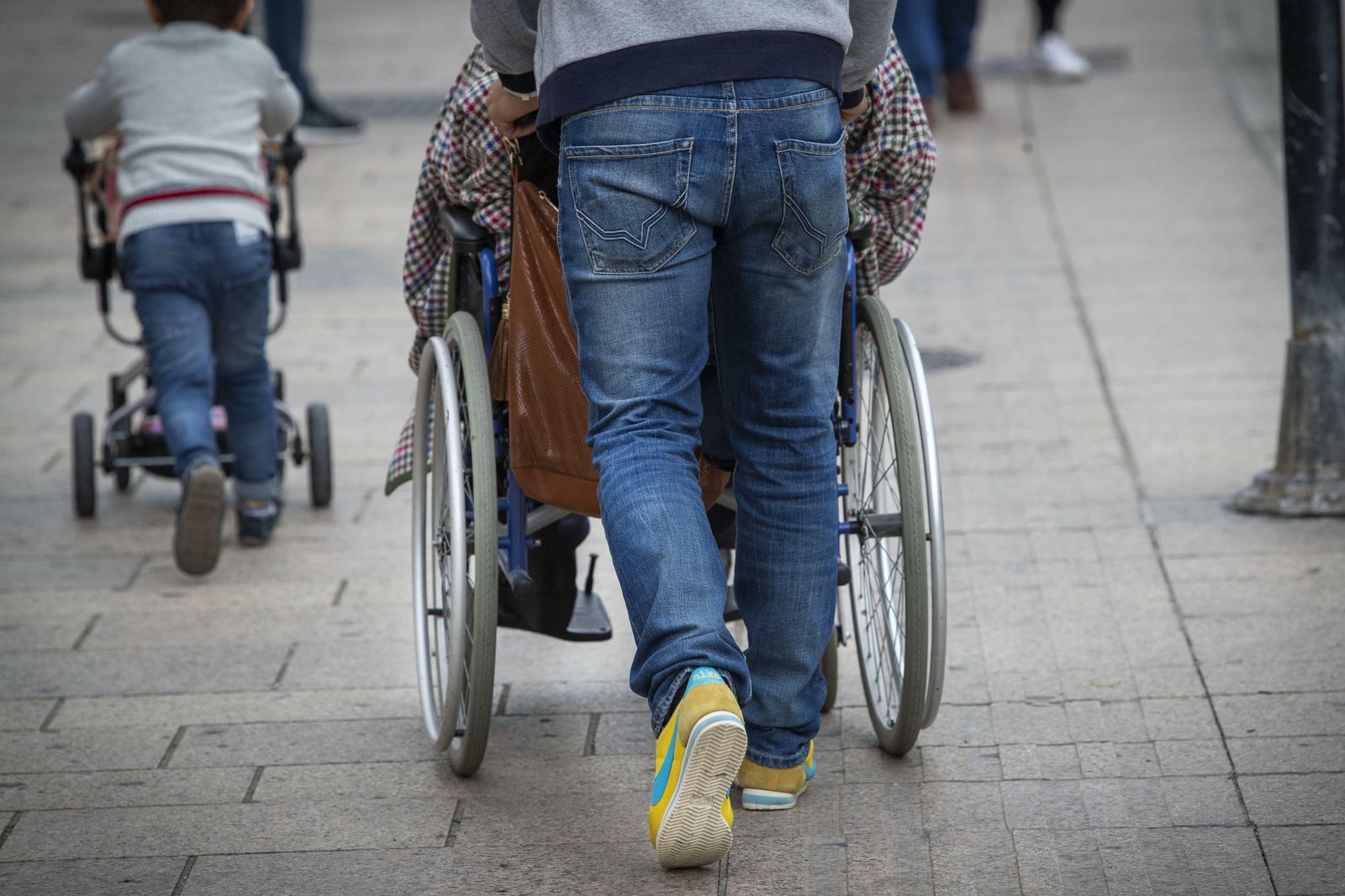 Una persona empuja la silla de ruedas de otra.
