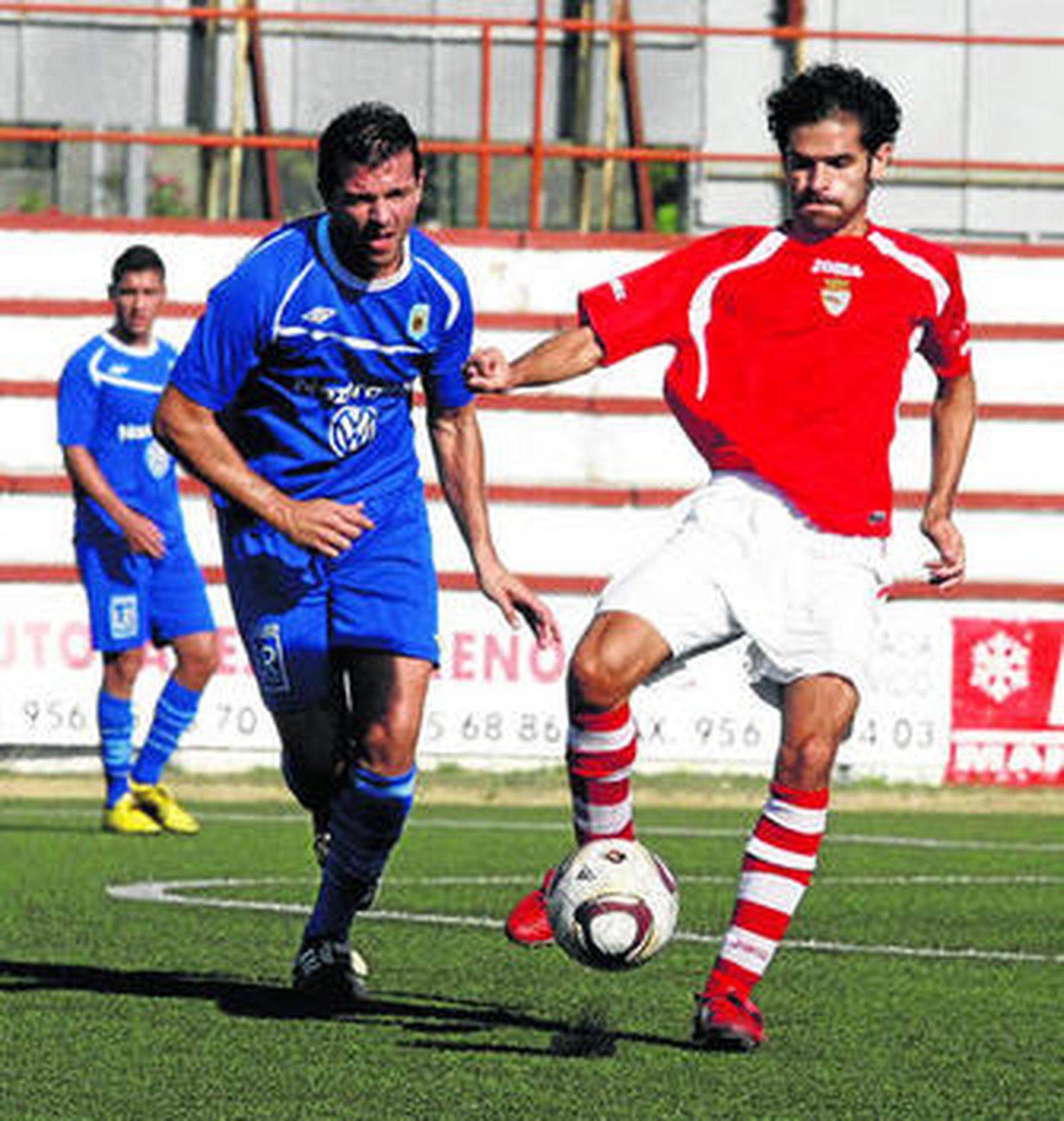 Luis Castillo (d) protege el cuero de un defensor sevillano poco antes de ser expulsado por protestar.