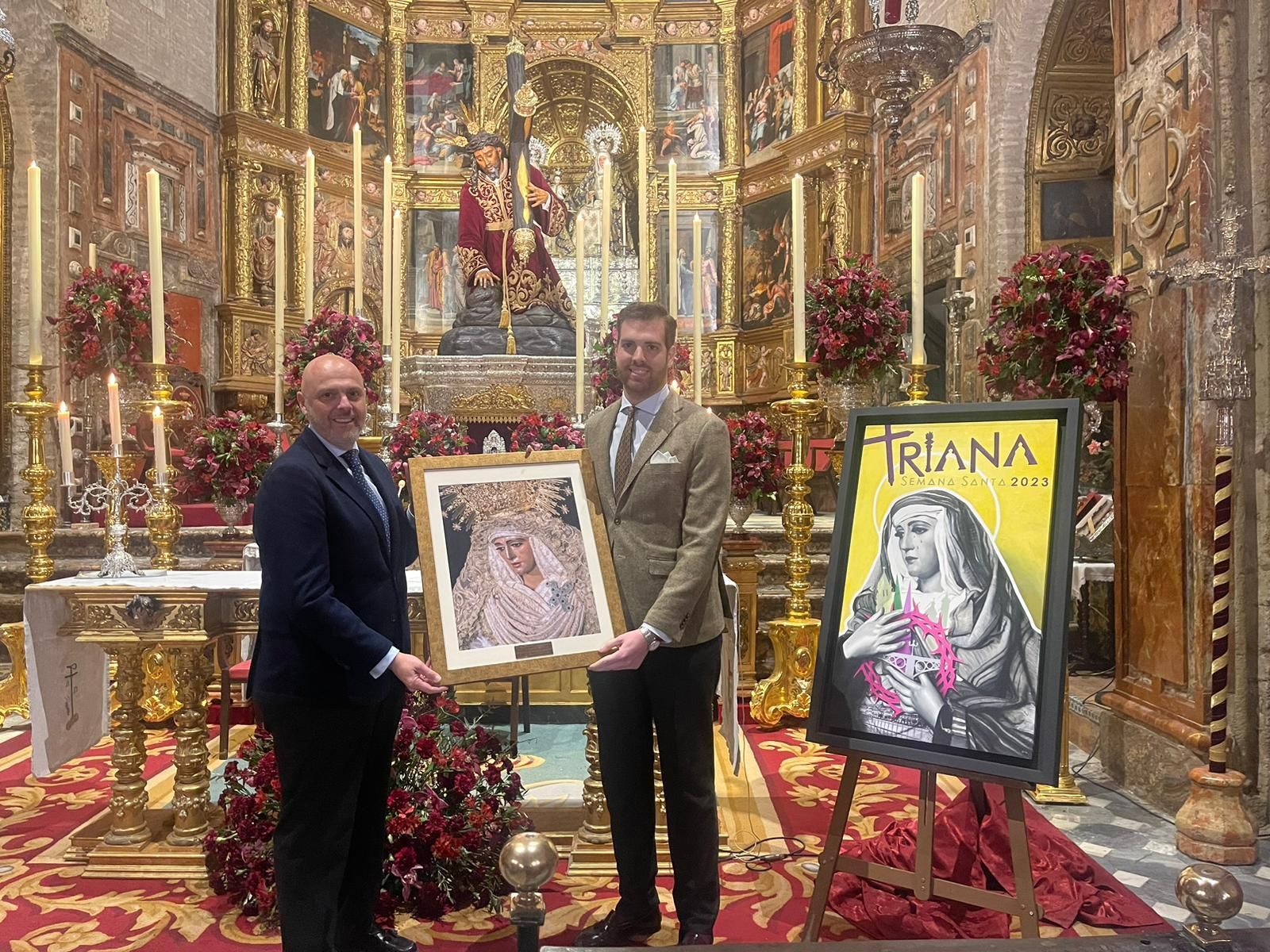 El hermano mayor de la Esperanza de Triana, Sergio Sopeña, entrega un cuadro al cartelista Ricardo Gil.