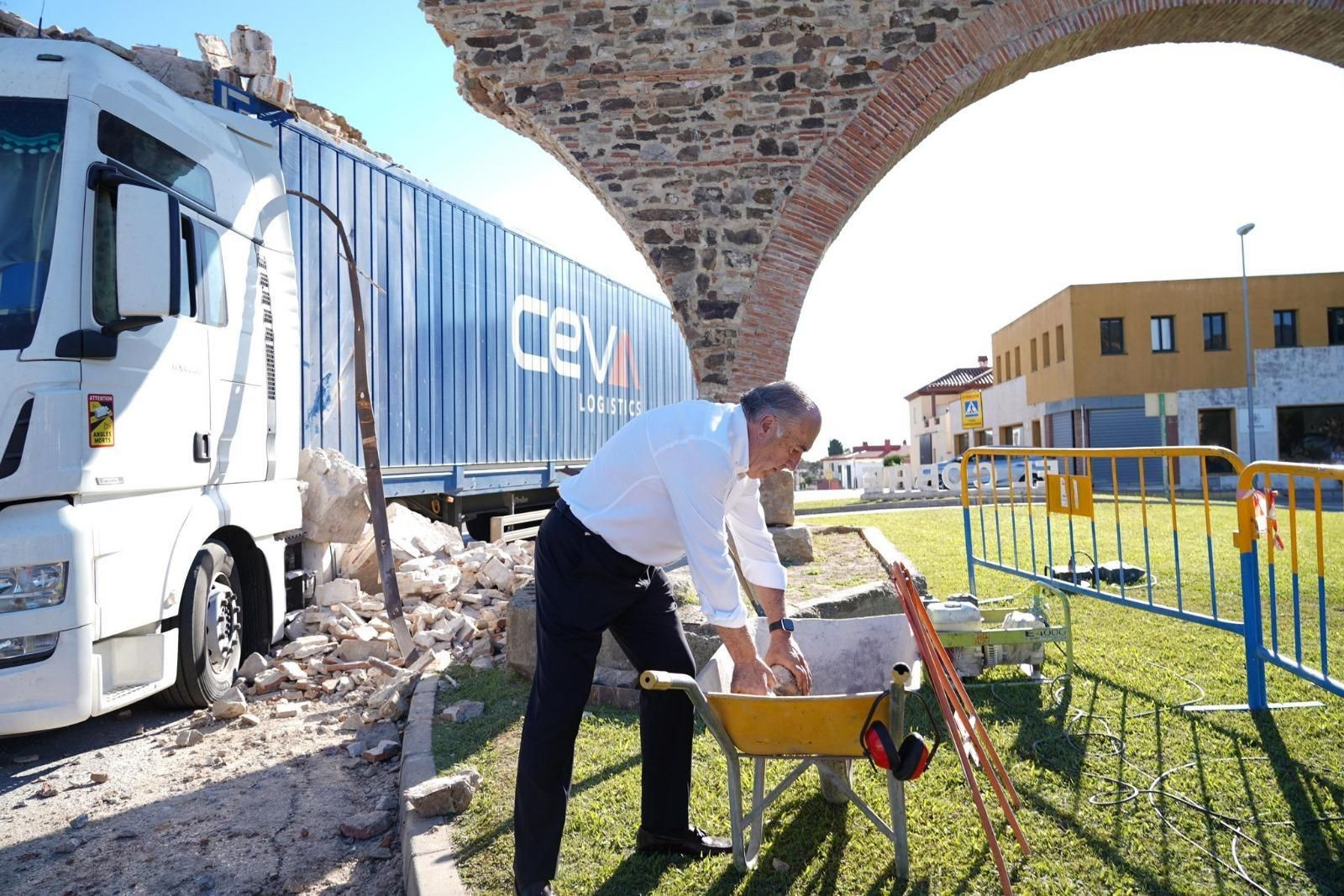 José Ignacio Landaluce, alcalde de Algeciras, coloca varios de los ladrillos del arco en una carretilla.