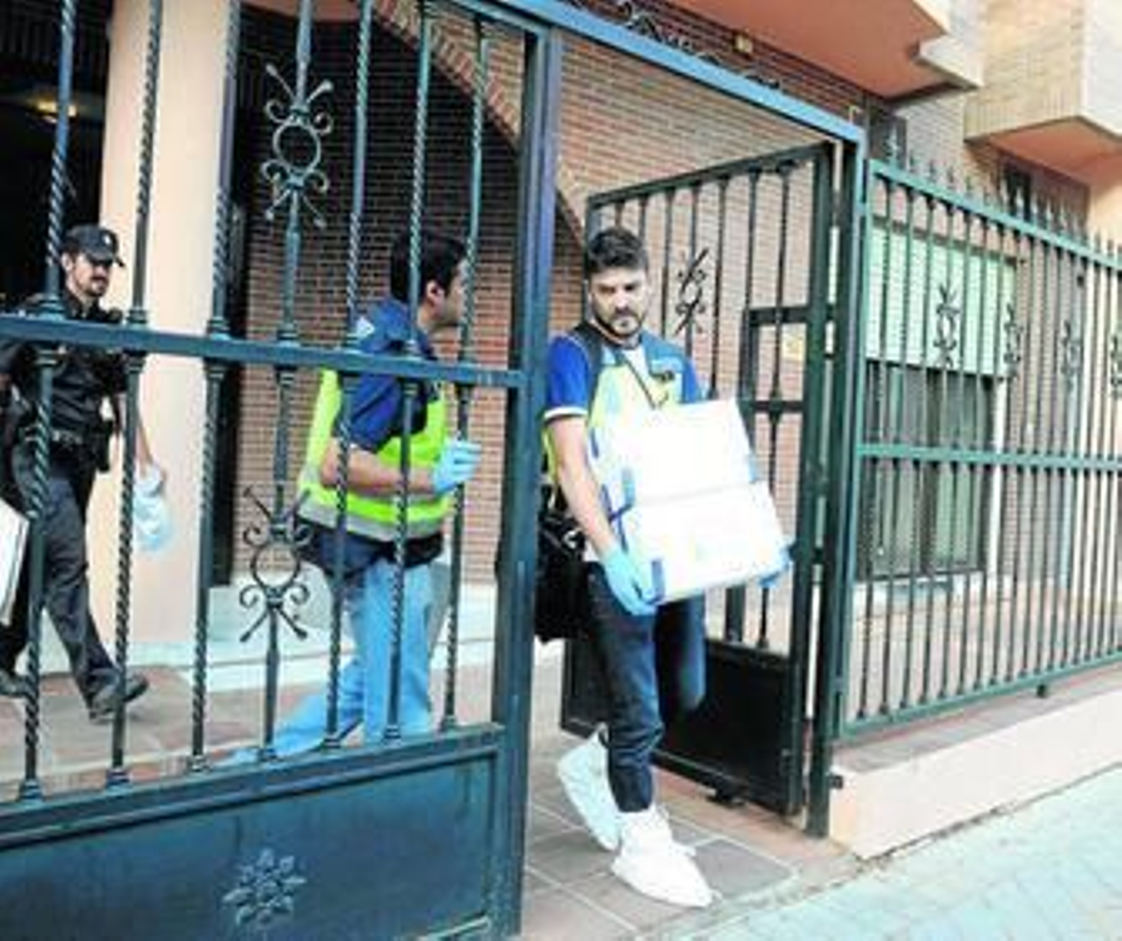 Agentes de la Policía Científica abandonan el edificio de Granada donde una mujer fue hallada muerta de madrugada.