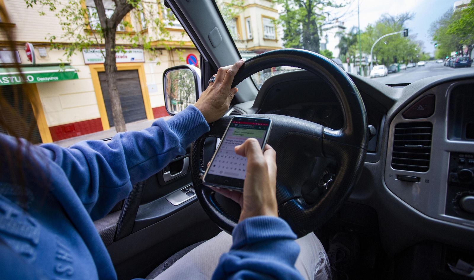 Una conductora consulta el móvil.
