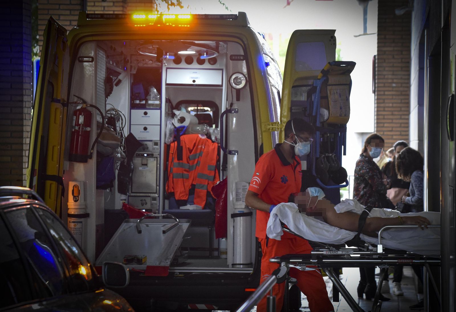 Personal del servicio de emergencias sanitarias traslada a un enfermo en camilla a las Urgencias del Virgen Macarena.