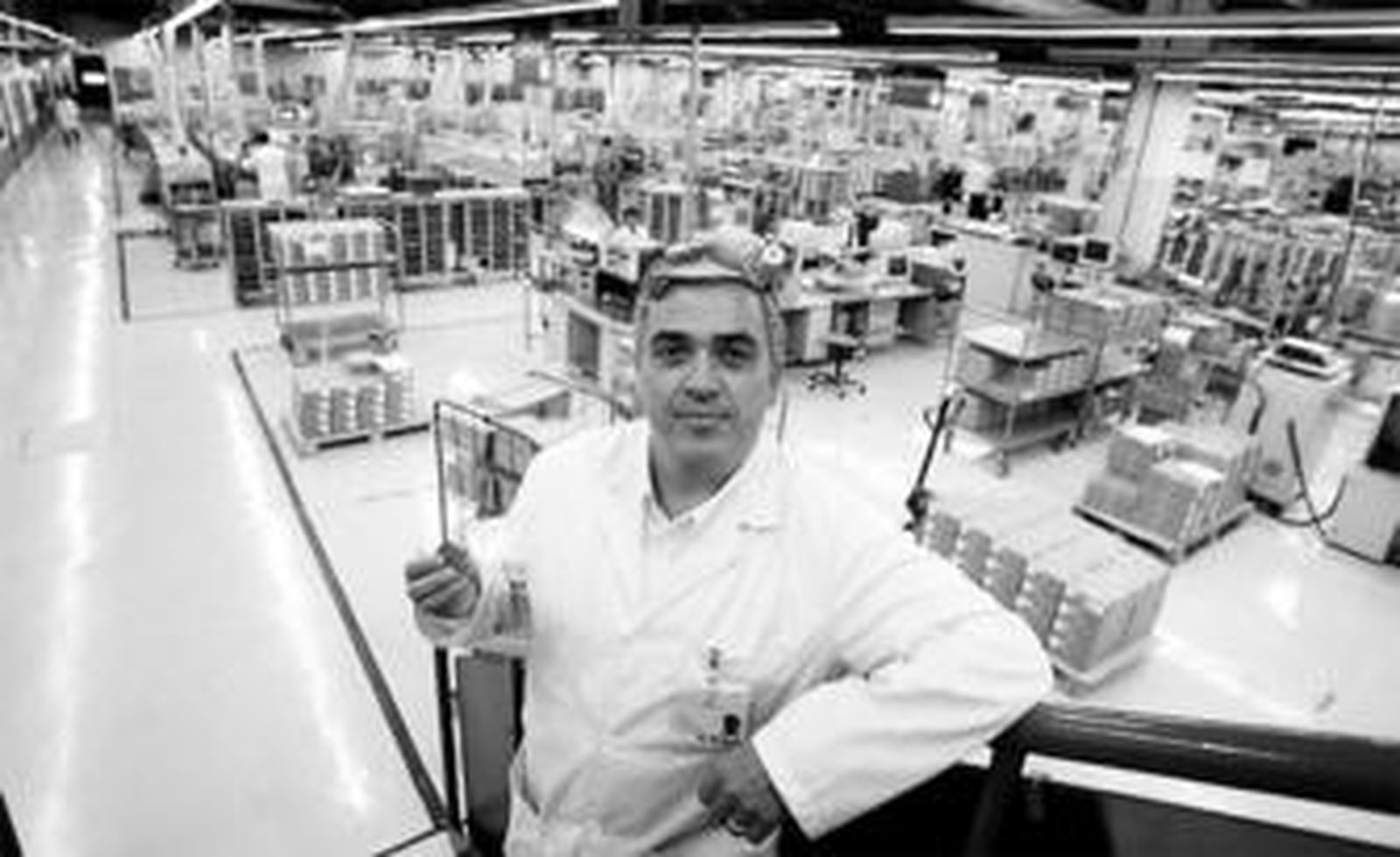 Joao Lobo, director de la fábrica de Epcos en Málaga, muestra un pequeño condensador de cinta con la planta de fondo.