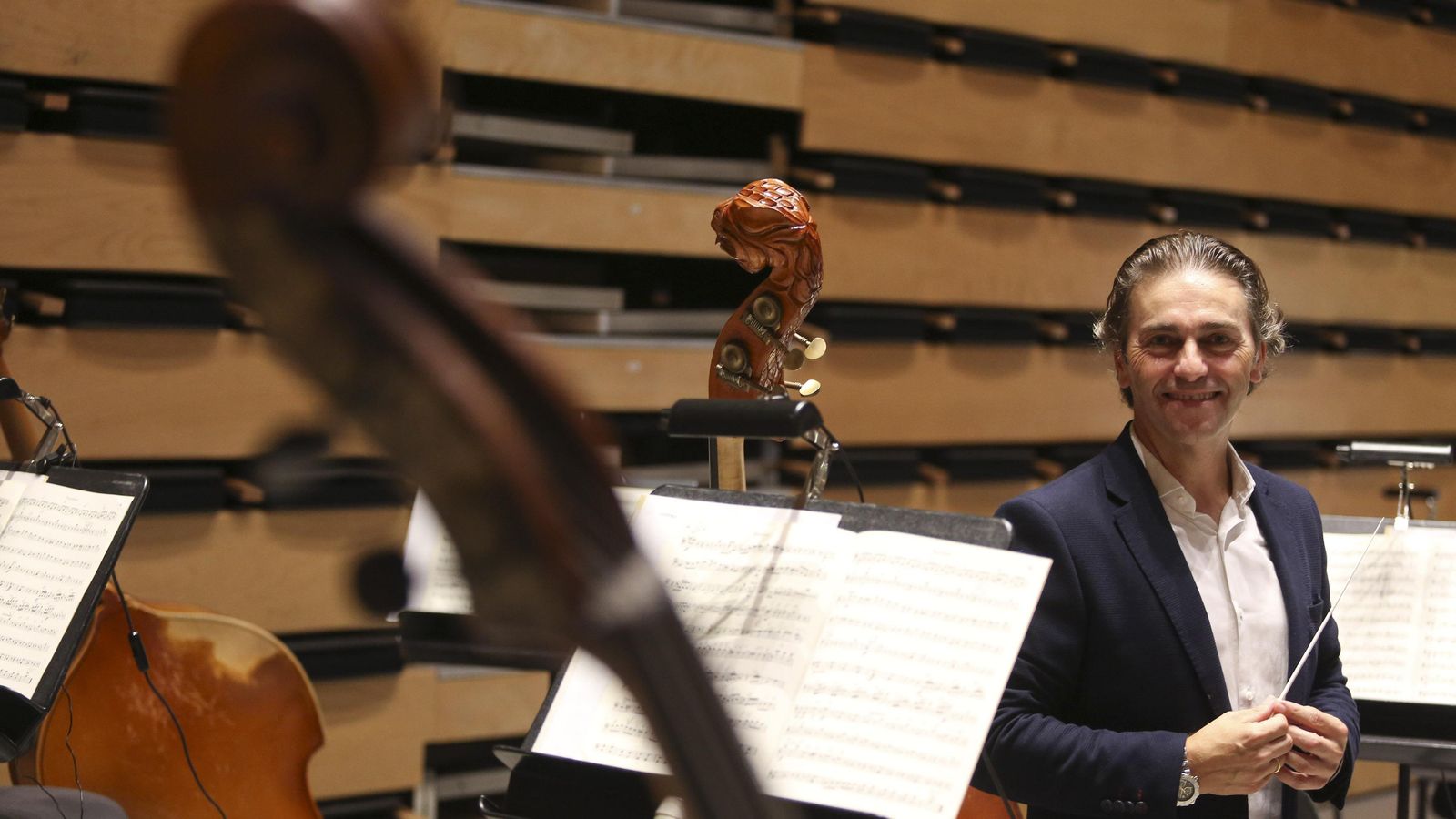 El director, junto a los contrabajos de la orquesta.