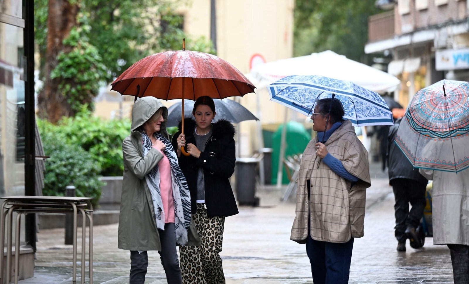 Varias personas se protegen de la lluvia en Córdoba.