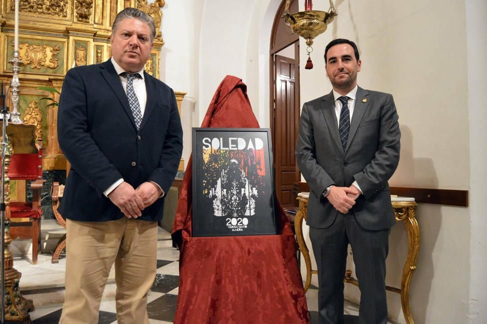 Los concejales Diego Cruz y Carlos Sánchez junto a este cartel de la Soledad.
