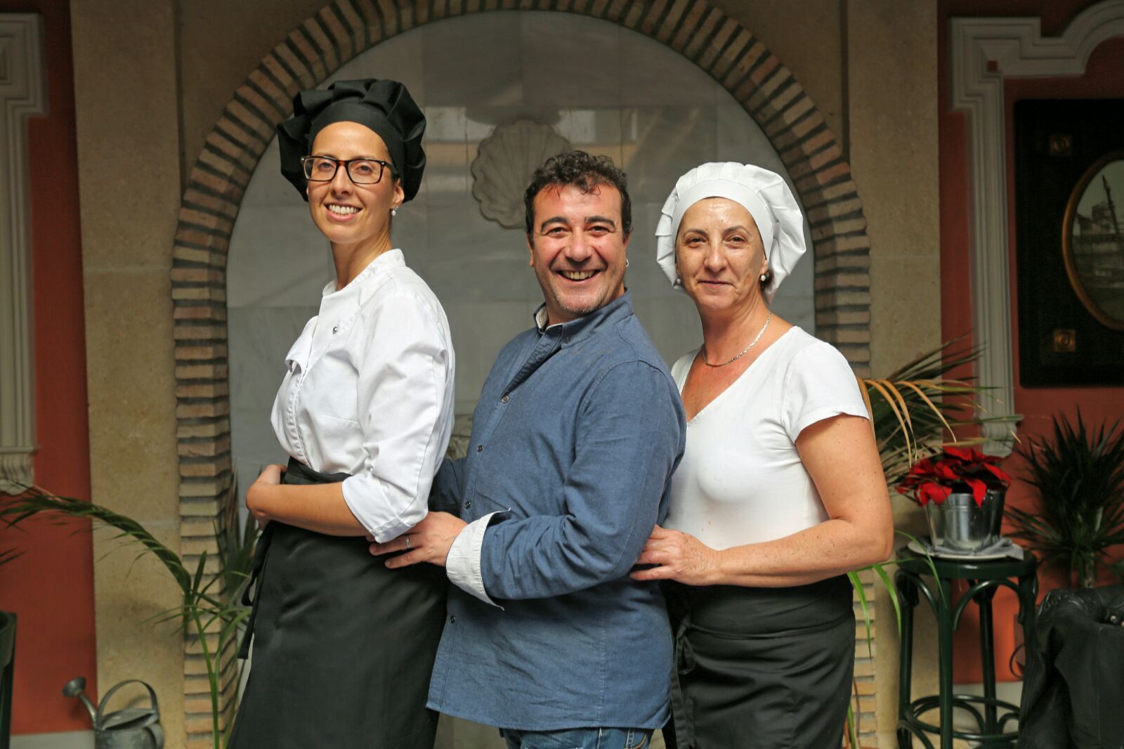 El actor portuense Juanjo Macías, en el patio del restaurante Zaccaría posando con dos de las cocineras.