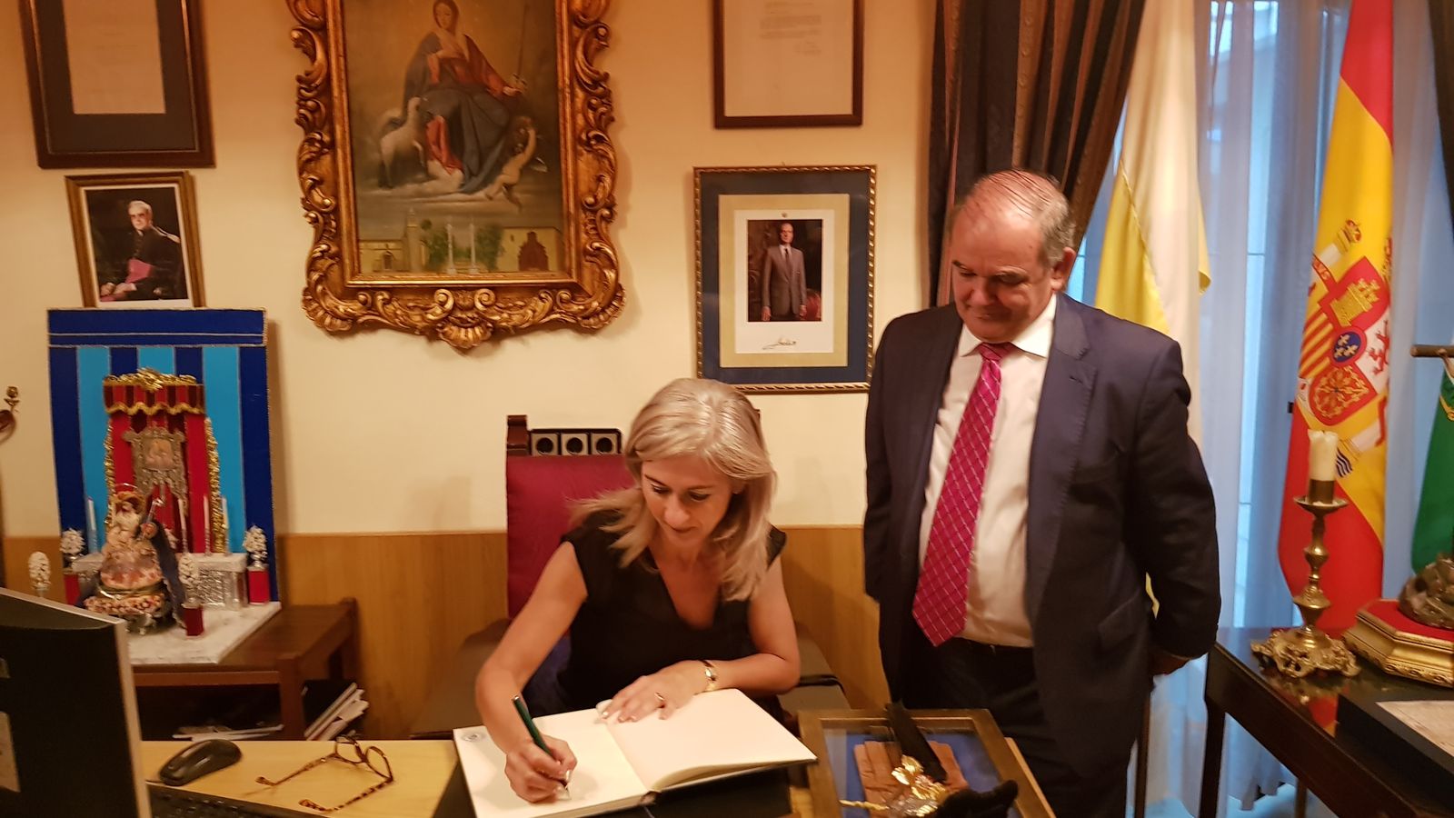 La consejera firma en el libro de honor de la hemandad en presencia de Andrés Martín