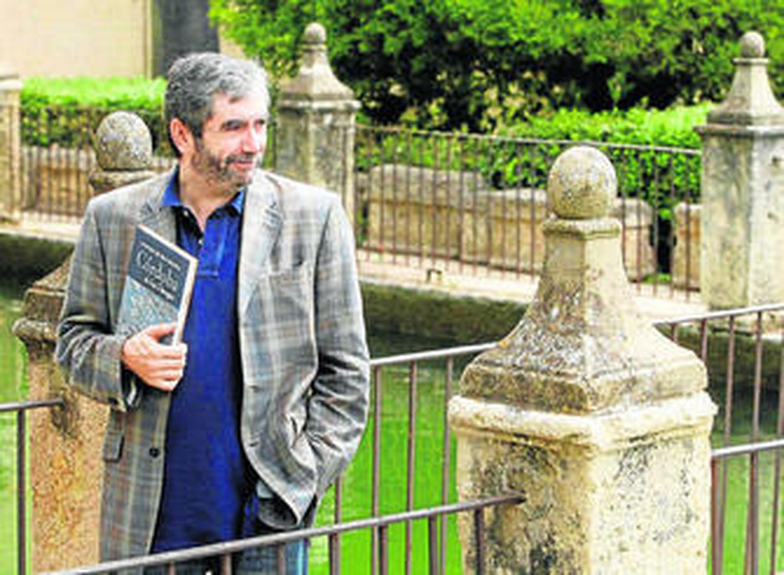 Muñoz Molina, en el Alcázar de los Reyes Cristianos en 2007, con un ejemplar de 'Córdoba de los Omeyas'.