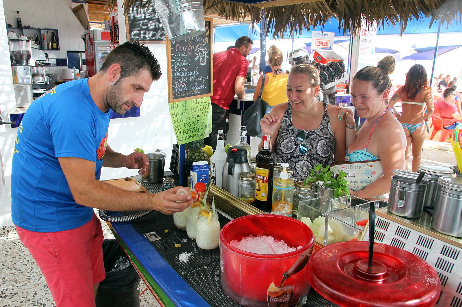 Un camarero sirve a unas clientas en un chiringuito de Punta Umbría.