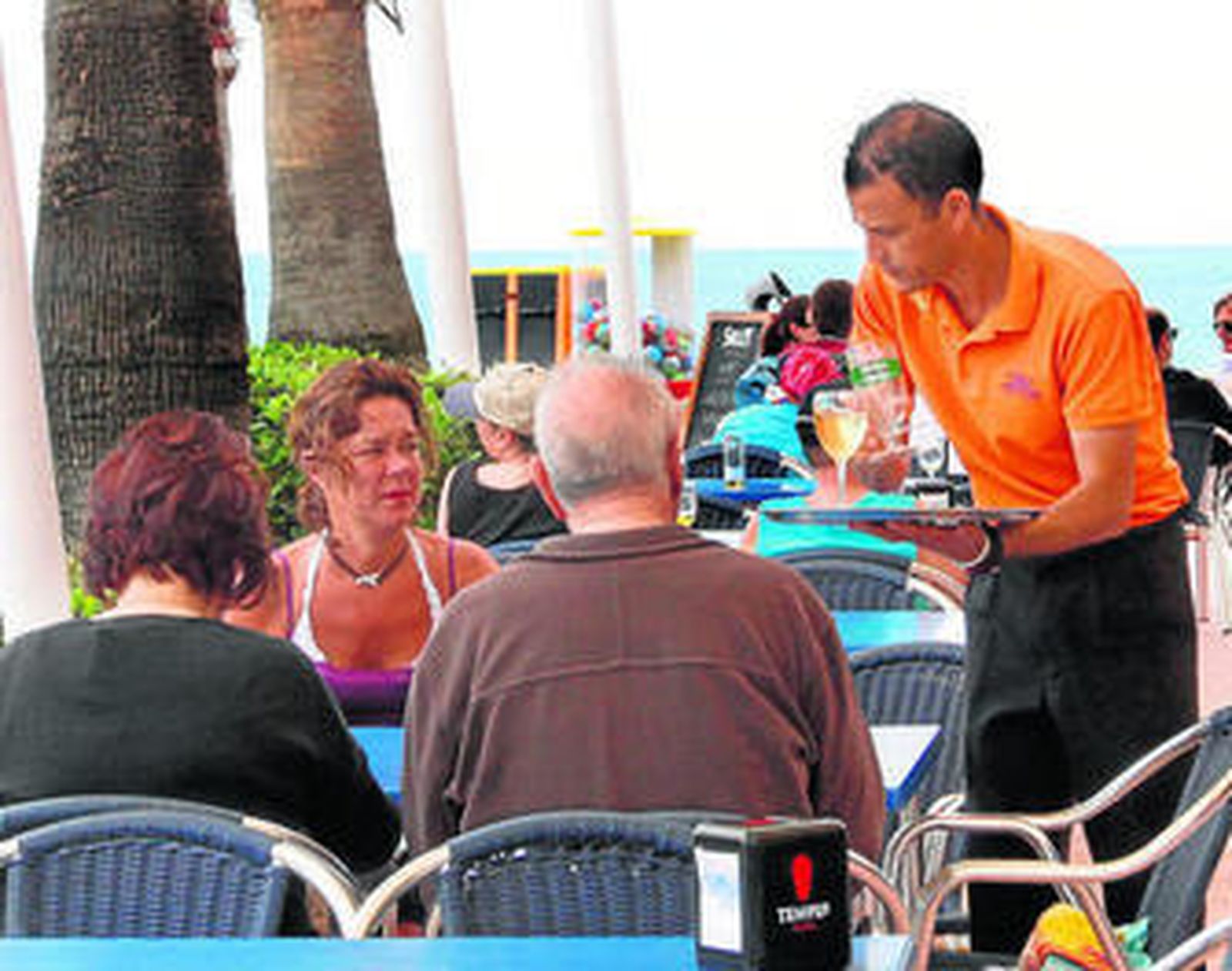 Un camarero sirve en una de las terrazas del Paseo Marítimo.