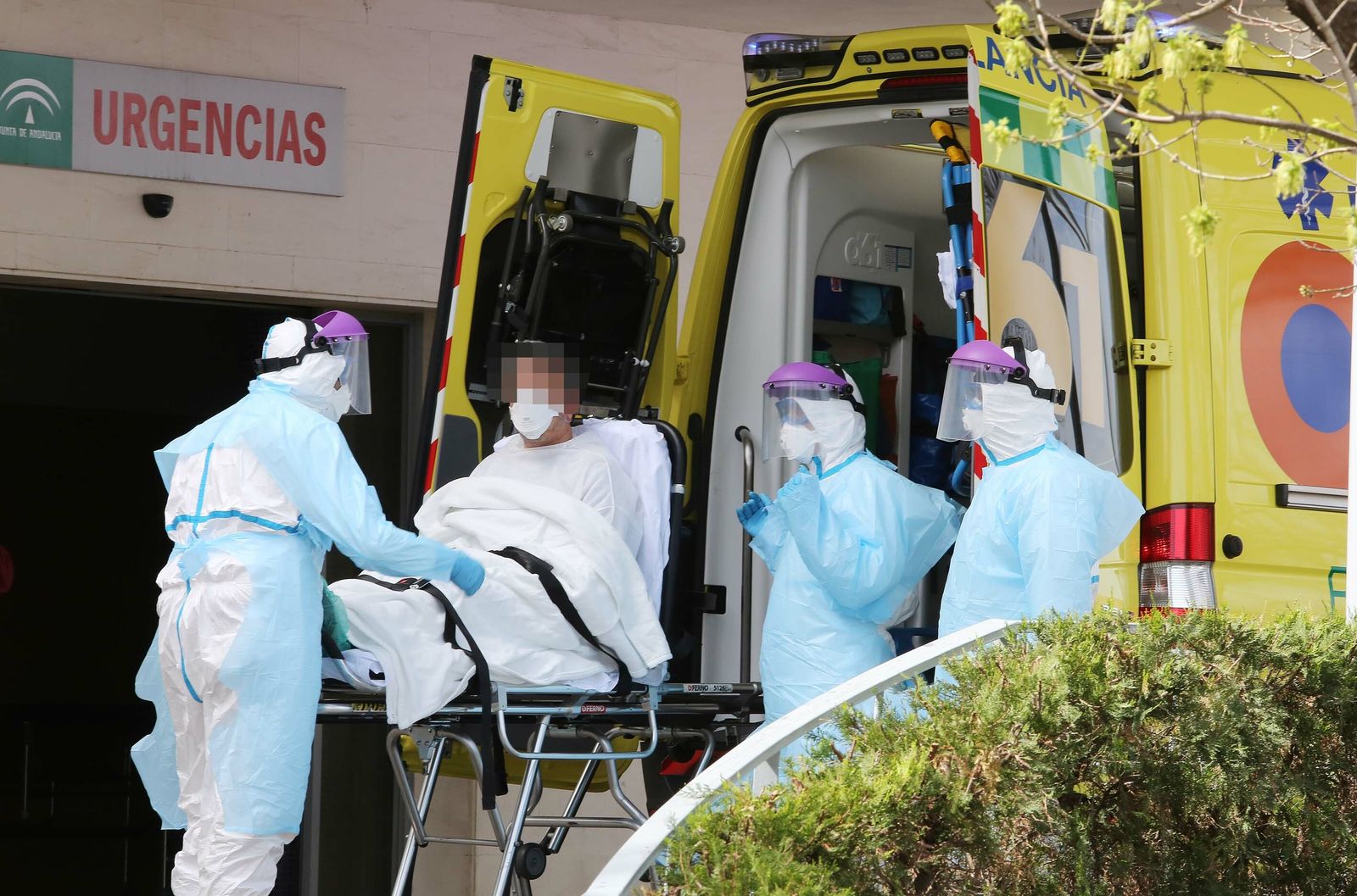 Sanitarios debidamente protegidos bajando de la ambulancia a un paciente considerado como caso sospechoso este jueves en las Urgencias de Jerez.